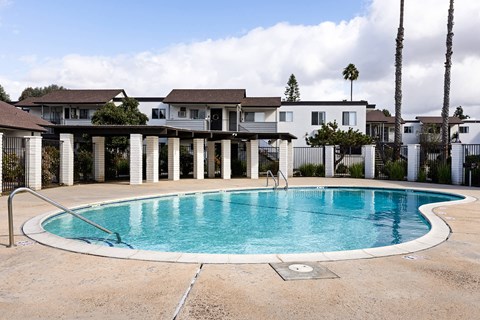 A swimming pool in front of a row of houses.