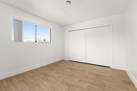 A room with a sliding door and a window with blinds.