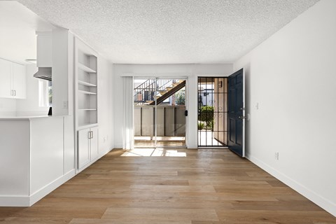 A long hallway with a wooden floor and white walls.