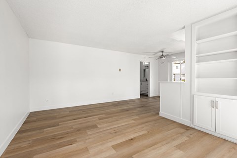 A room with wooden flooring and white walls.