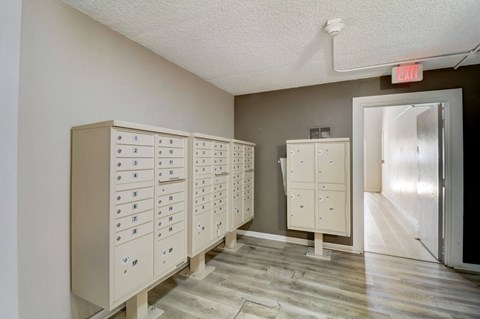 A room with a row of filing cabinets and a red exit sign above them.