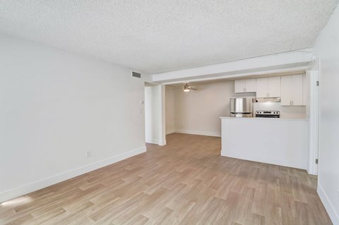 A room with a kitchenette in the middle of it.