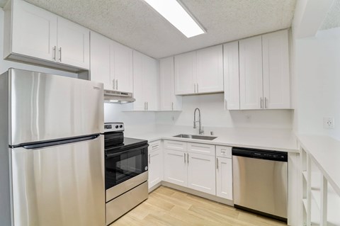 A kitchen with white cabinets and stainless steel appliances.