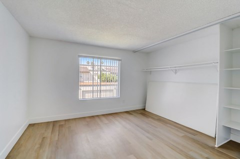 Empty room with a window and wooden flooring.