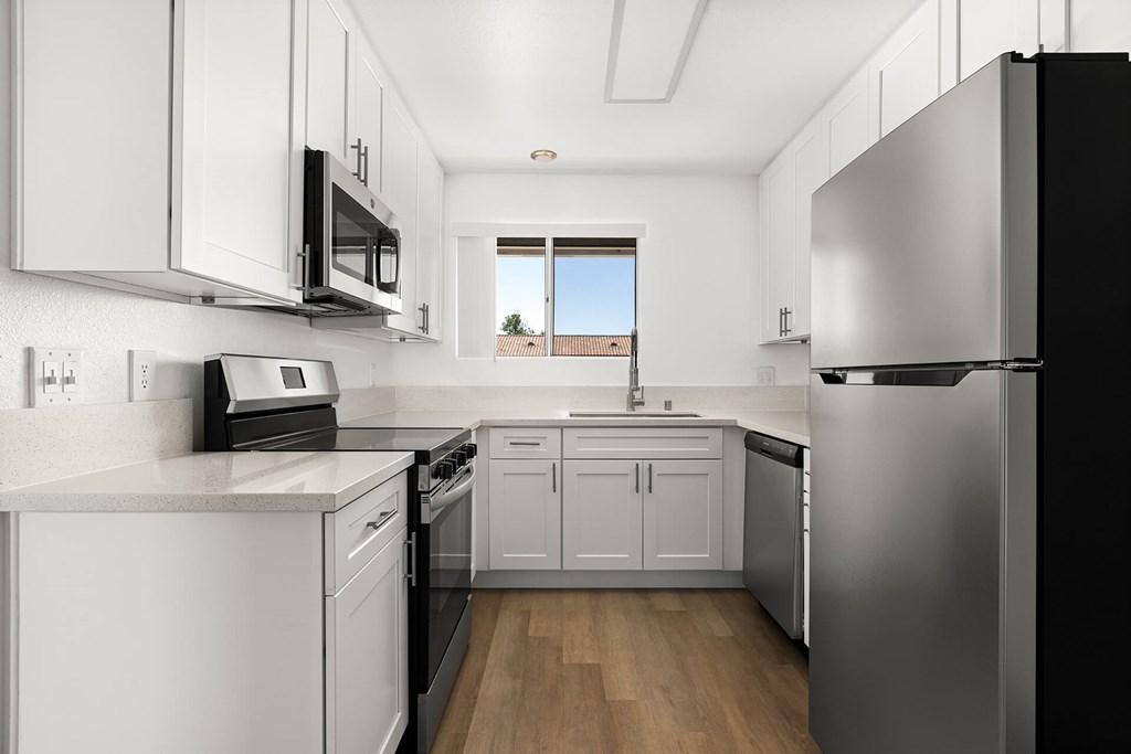 A modern kitchen with stainless steel appliances and white cabinets.