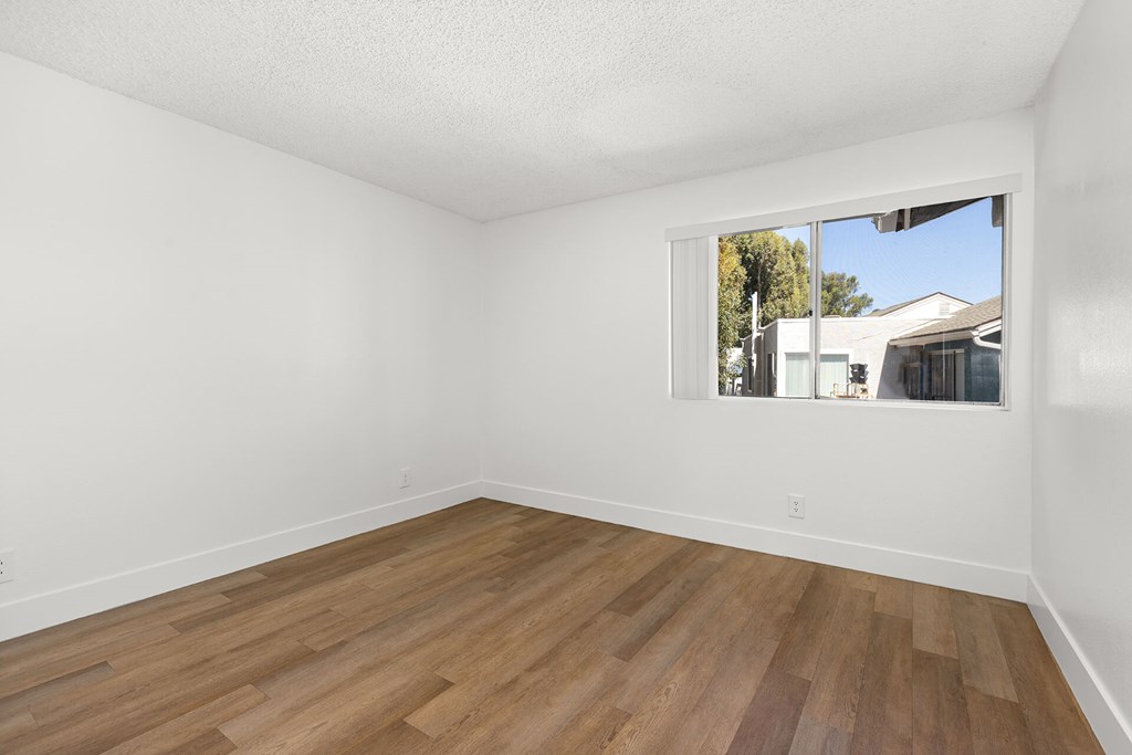 Empty room with wooden floor and a window.