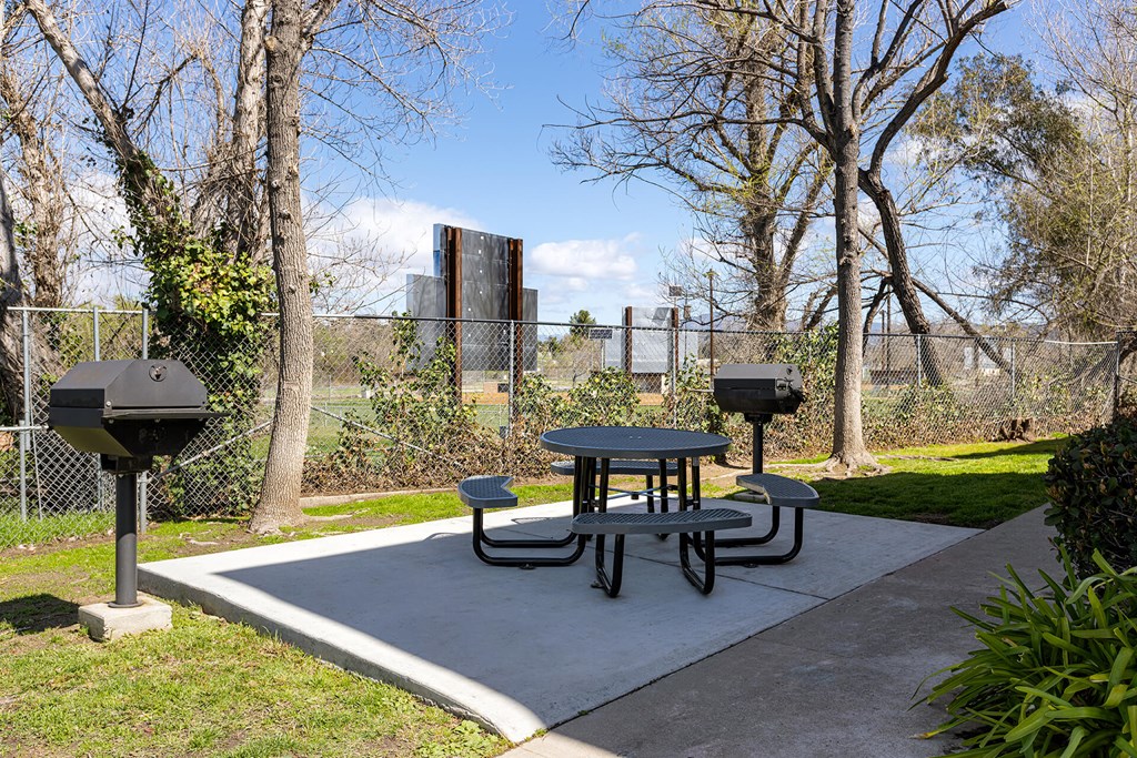 A picnic table is surrounded by a chain link fence.