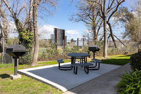 A picnic table is surrounded by a chain link fence.
