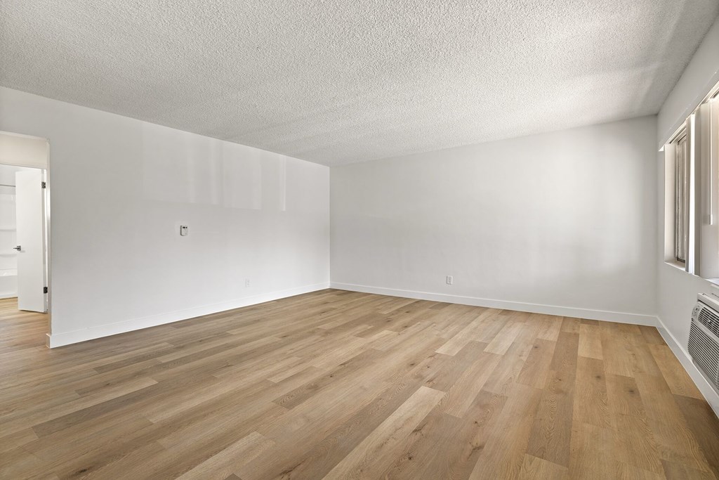A room with wooden flooring and white walls.