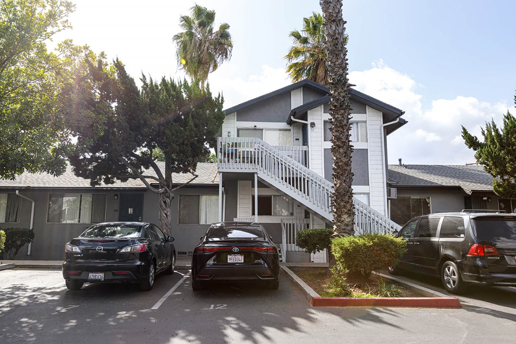 A black car is parked in front of a house.