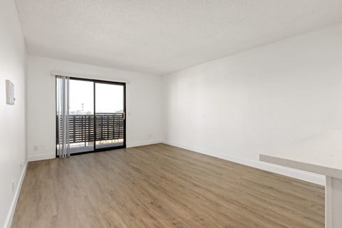 A room with wooden flooring and a sliding glass door.