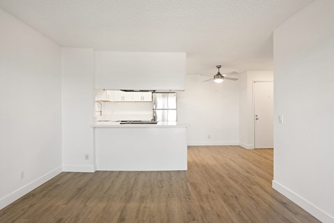 A room with a window and a fan on the ceiling.