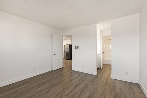 A large empty room with wooden floors and white walls.