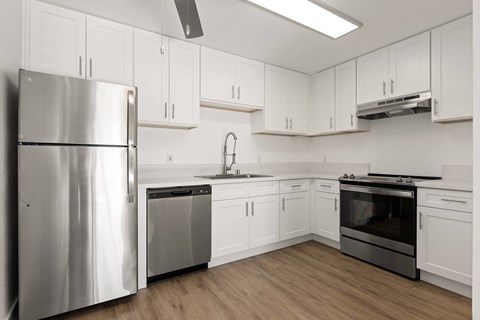 A modern kitchen with stainless steel appliances and white cabinets.
