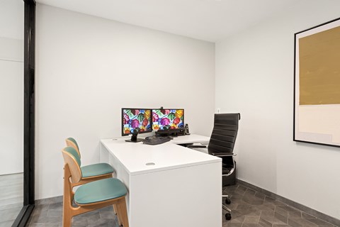 A white desk with a computer and a chair in front of it.