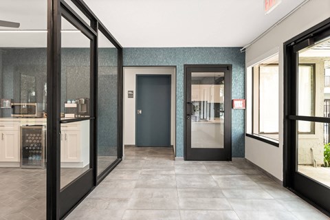 A hallway with a black door and a black framed window.