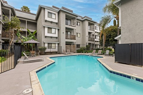 A swimming pool in front of apartment buildings.
