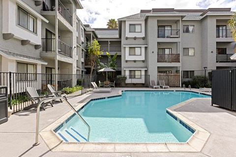 A swimming pool in front of apartment buildings.