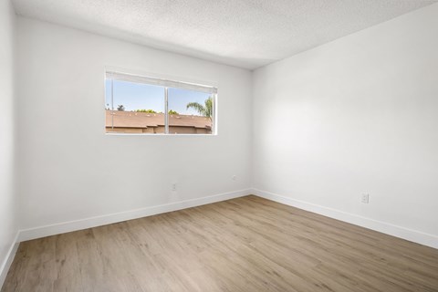A room with a window showing a view of a building outside.