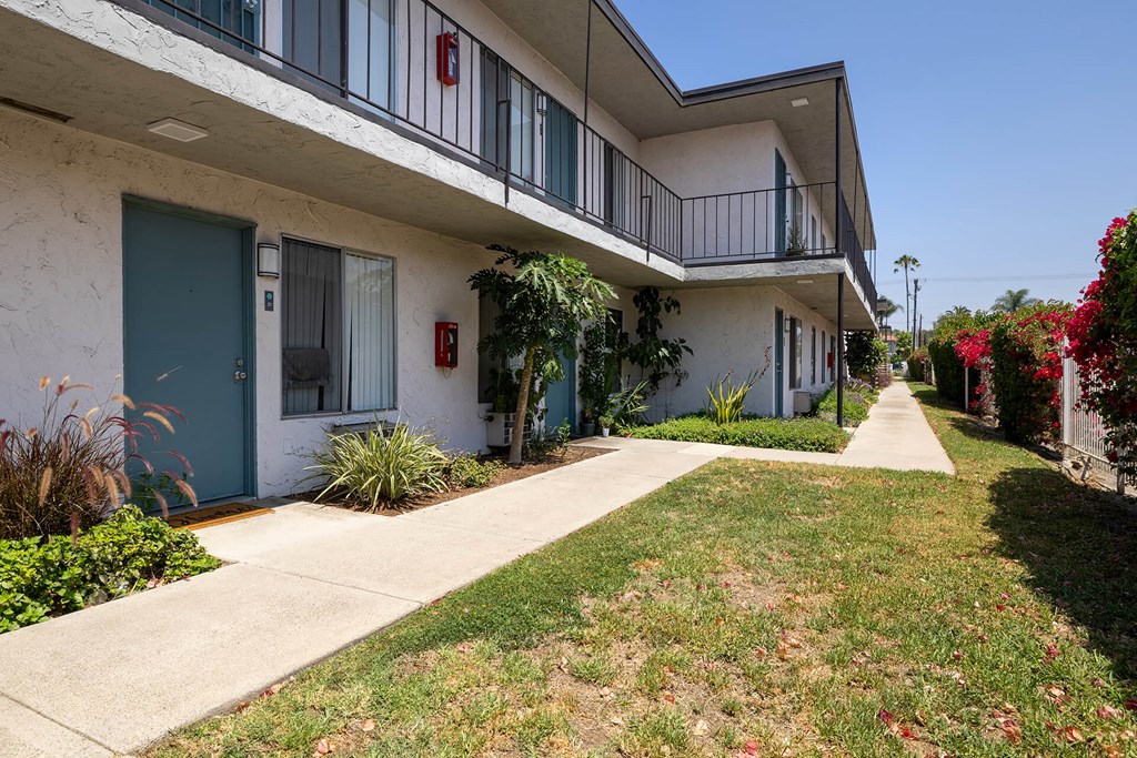 A white building with a blue door and a red fire hydrant.