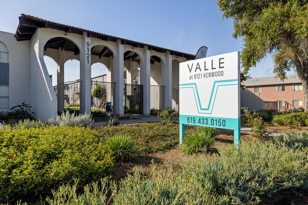 A sign for Valle at 9121 Kenwood stands in front of a building.