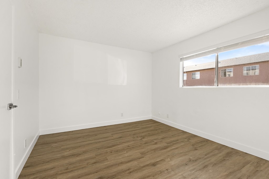 Empty room with wooden floor and white walls.