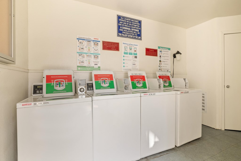 A row of washing machines are lined up in a laundromat.