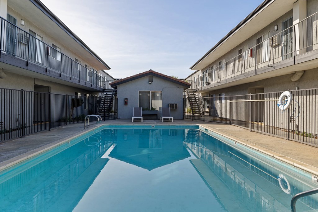 A swimming pool in a residential area surrounded by apartment buildings.
