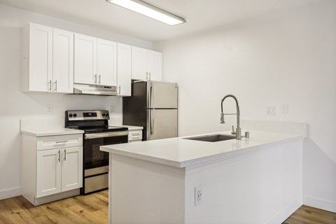 A kitchen with white cabinets and appliances.