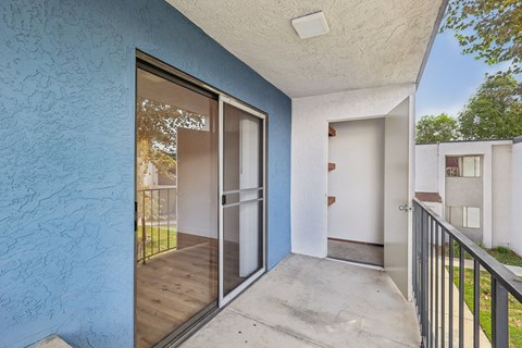 A balcony with a glass door leading to a patio.