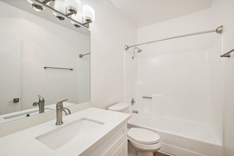 A white bathroom with a sink, toilet, and bathtub.