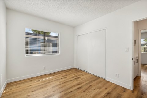A room with a window and wooden floors.