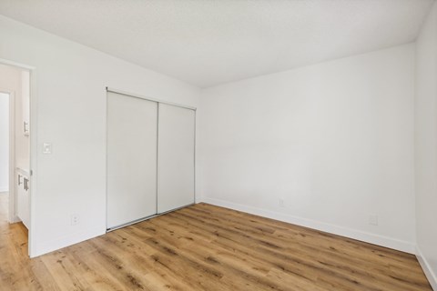 A room with a sliding door and wooden flooring.