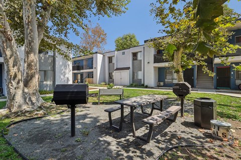 A mailbox sits in front of a picnic table in a courtyard.