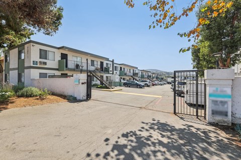 A gated entrance to a parking lot with a building in the background.