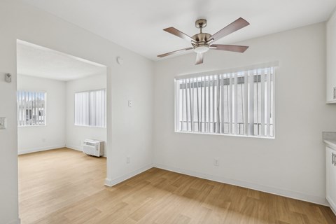 A room with a ceiling fan and a window with blinds.