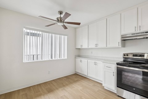 A kitchen with white cabinets and a black stove top oven.