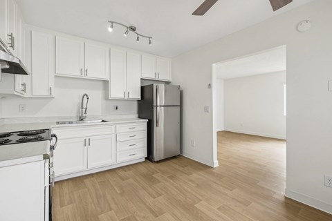 A kitchen with white cabinets and a black and white stove top.