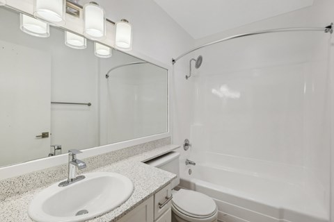 A white bathroom with a sink, toilet, and bathtub.