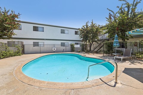 A small pool in a backyard with a fence around it.