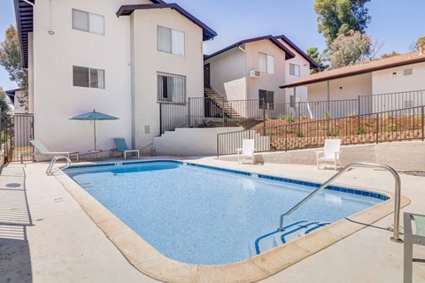 A small residential pool in front of a house.