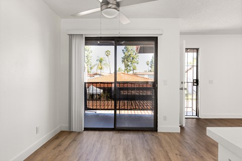 A room with a sliding glass door leading to a balcony.