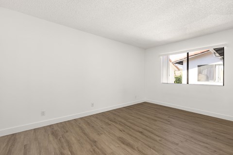 Empty room with wooden floor and a window.