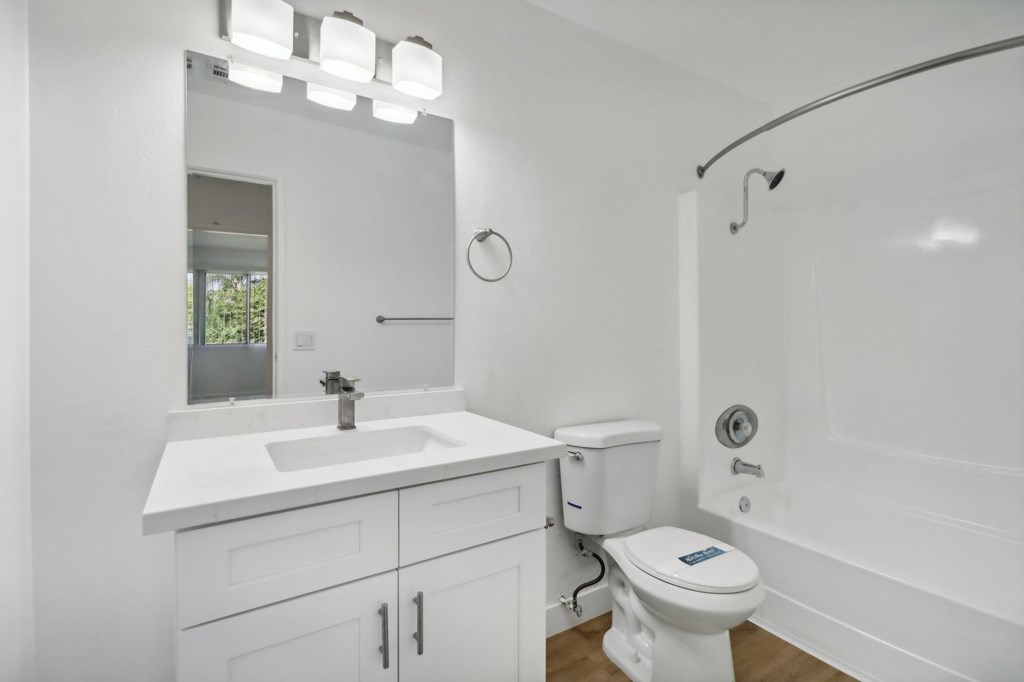 A white bathroom with a sink, toilet, and bathtub.