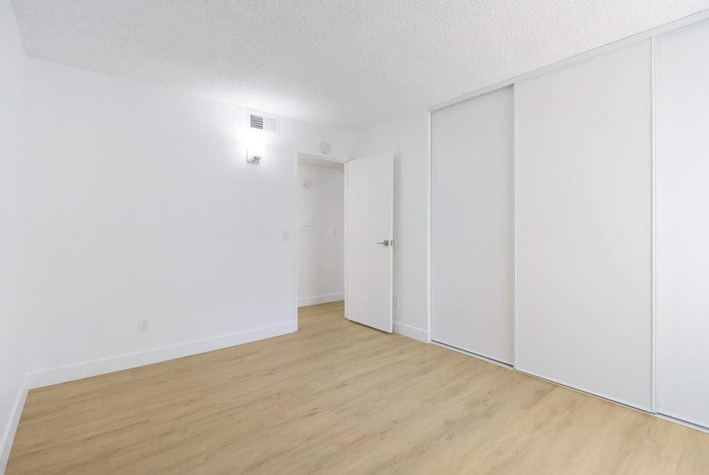 A room with a light on the wall and a door.