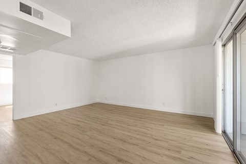 A room with wooden flooring and white walls.