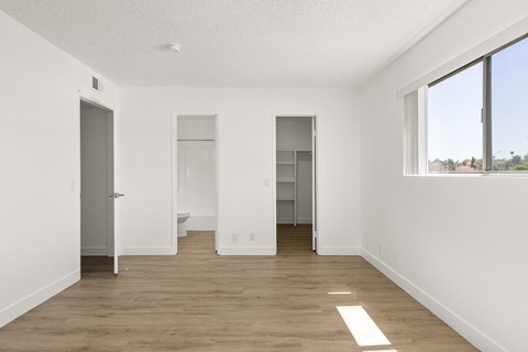 A large empty room with a toilet in the middle.