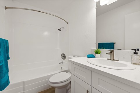 A white bathroom with a white toilet and a white sink.