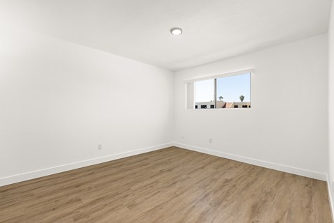 Empty room with wooden floor and a window.