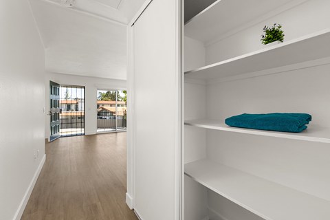 A white shelf with a blue towel on it.